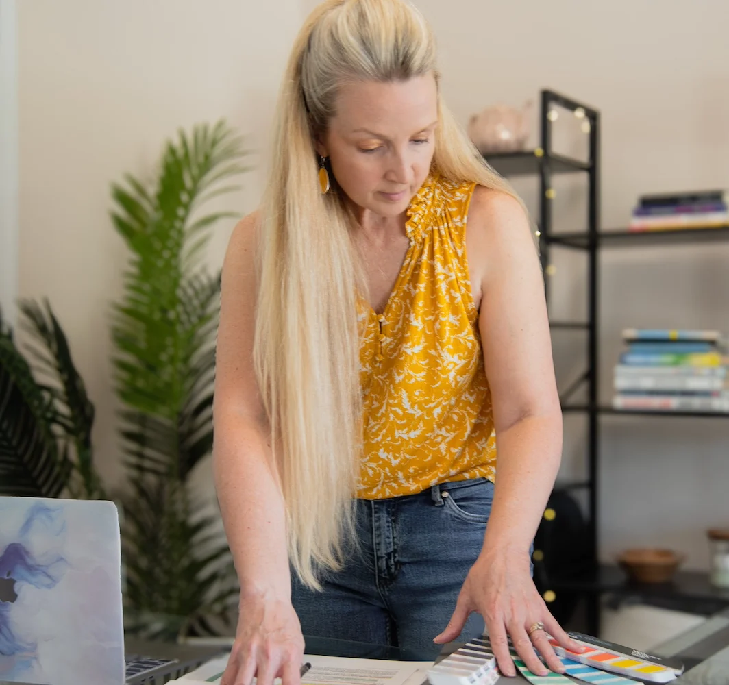 Suzette standing at her desk and organizing brand colors and messaging