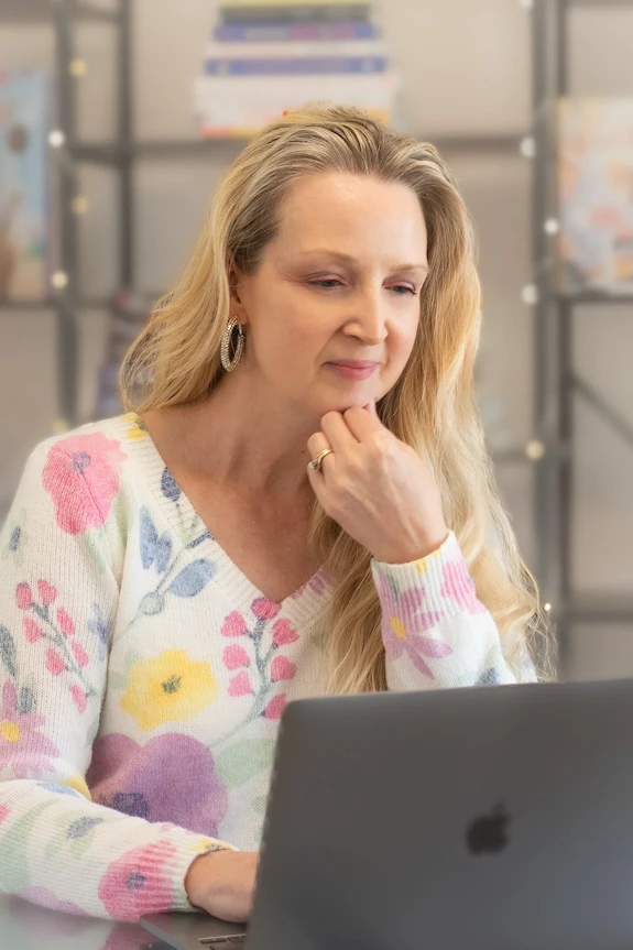 Suzette, with her laptop, concentrating on providing website copywriting services